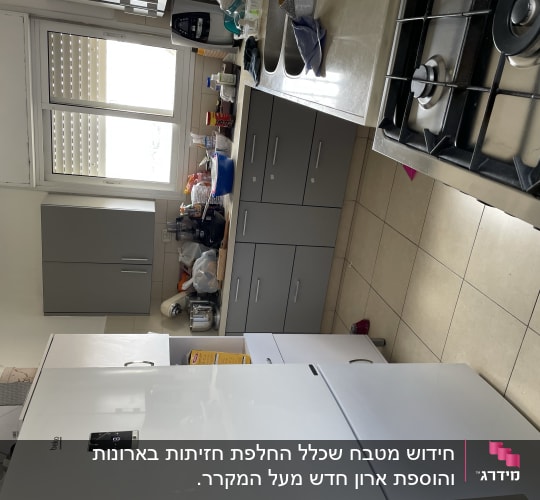 מטבח עם ארונות אפורים ומקרר לבן